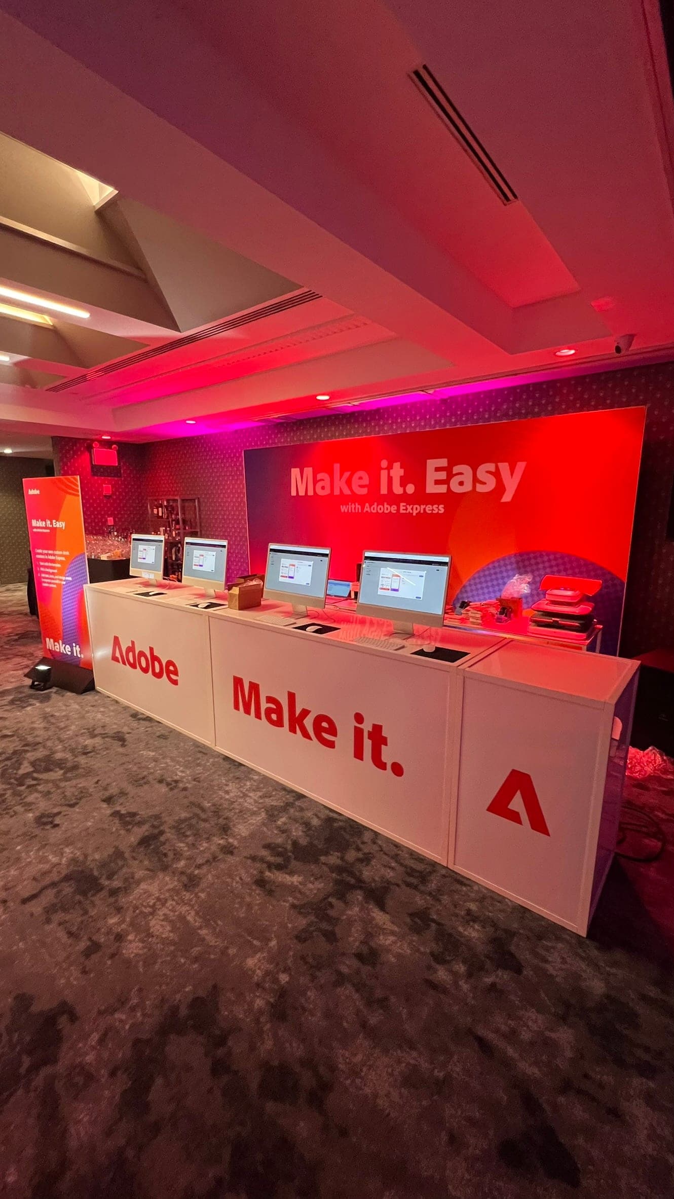Branded event atmosphere with red lighting and production stations
