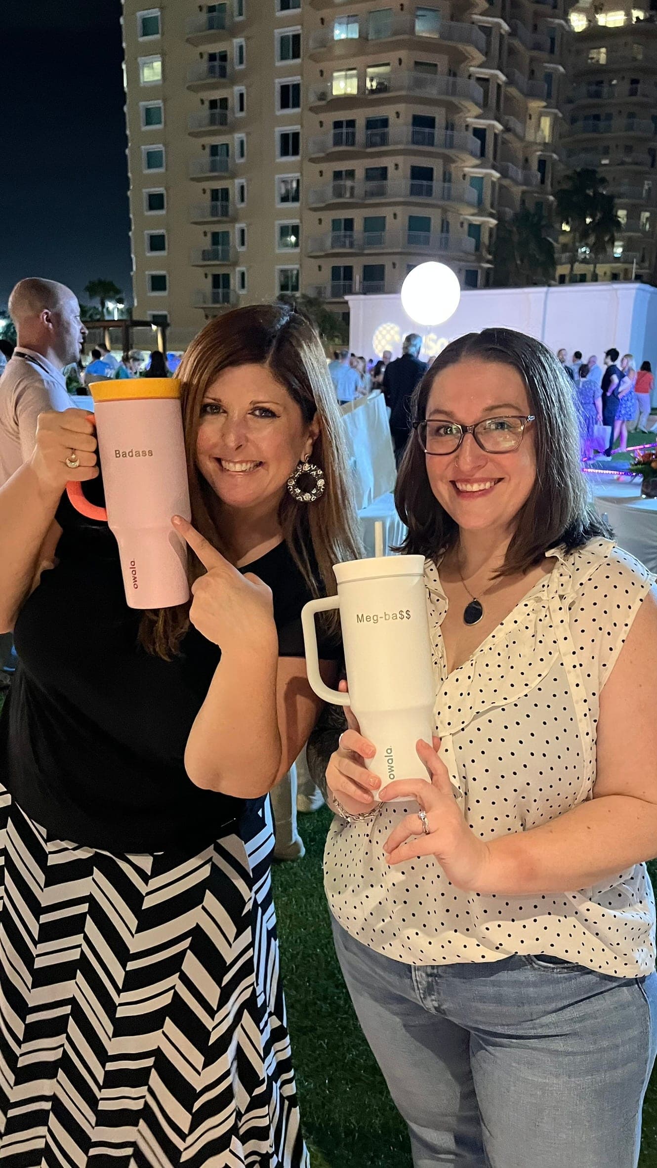 Guests holding personalized drinkware at an evening event